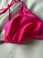 Pink bikini top on a light gray background