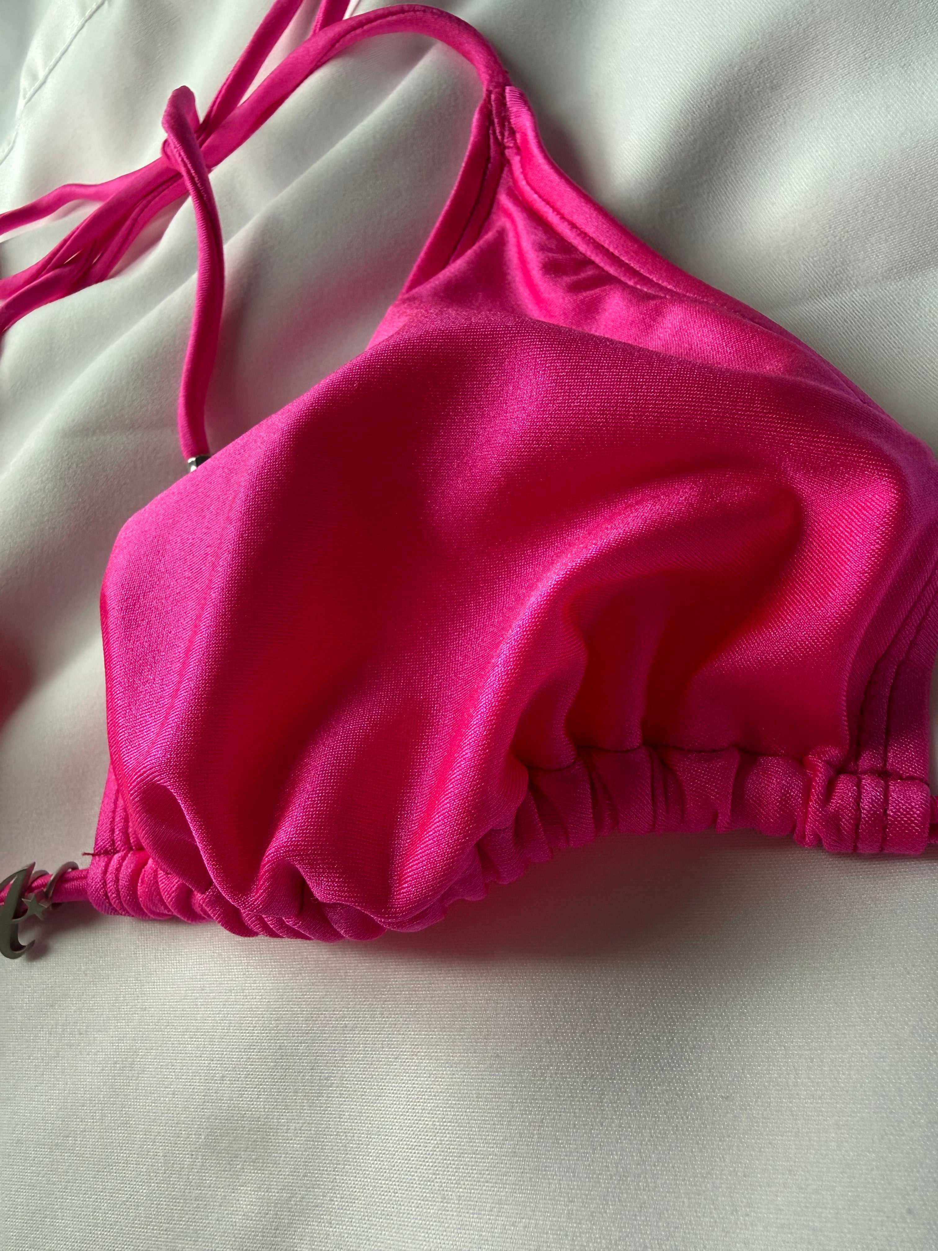 Pink bikini top on a light gray background